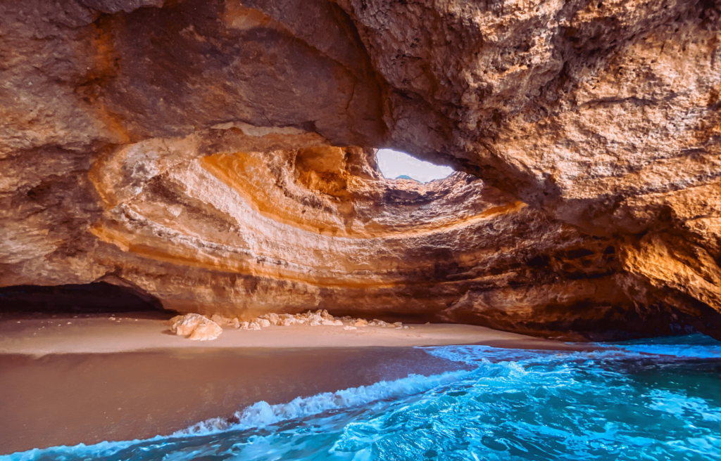 Inside a cave with rock walls and sky opening and ocean water