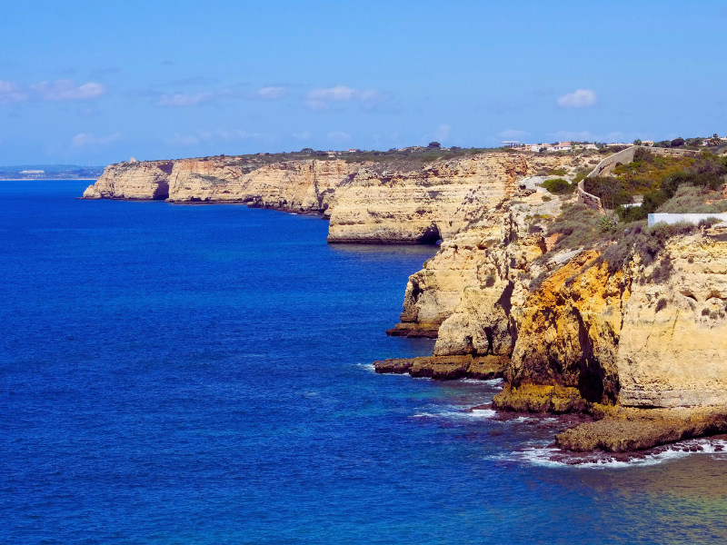 Coast with beige cliff at blue ocean