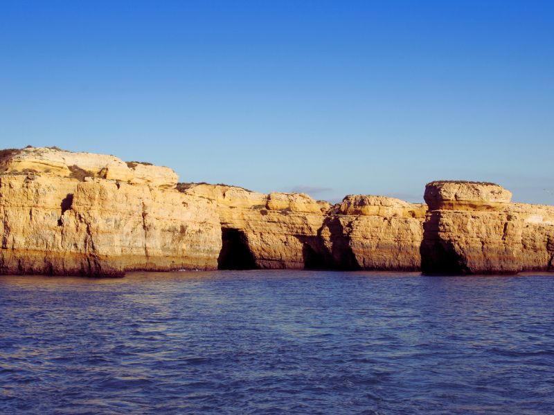 Coast with beige cliff at blue ocean